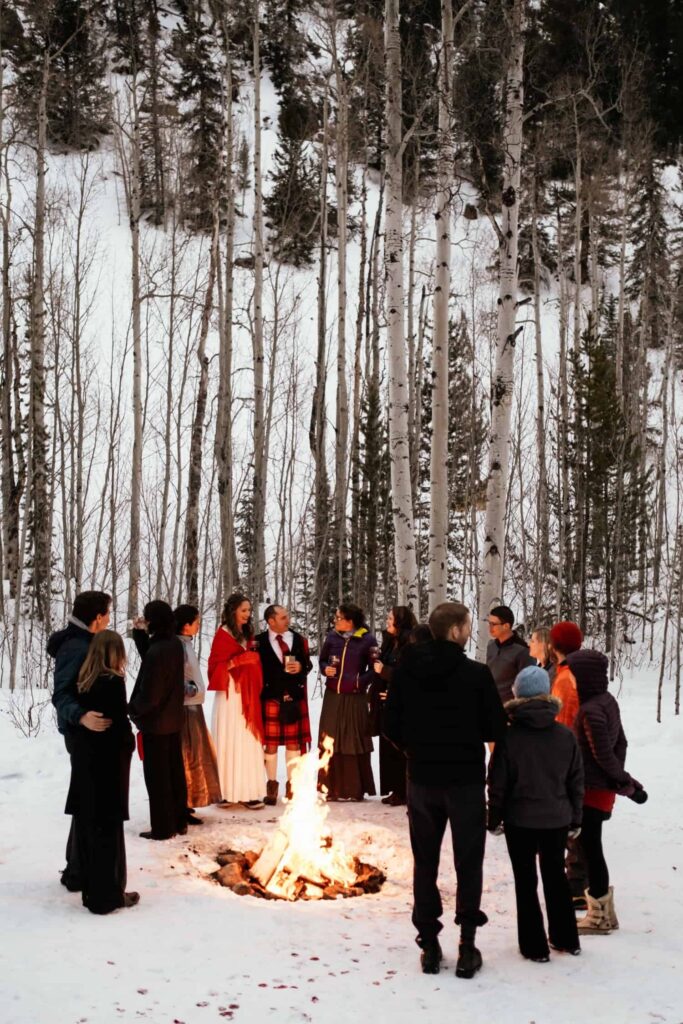 Couple standing next to bonfire with a handful of guests at Keystone Colorado elopement