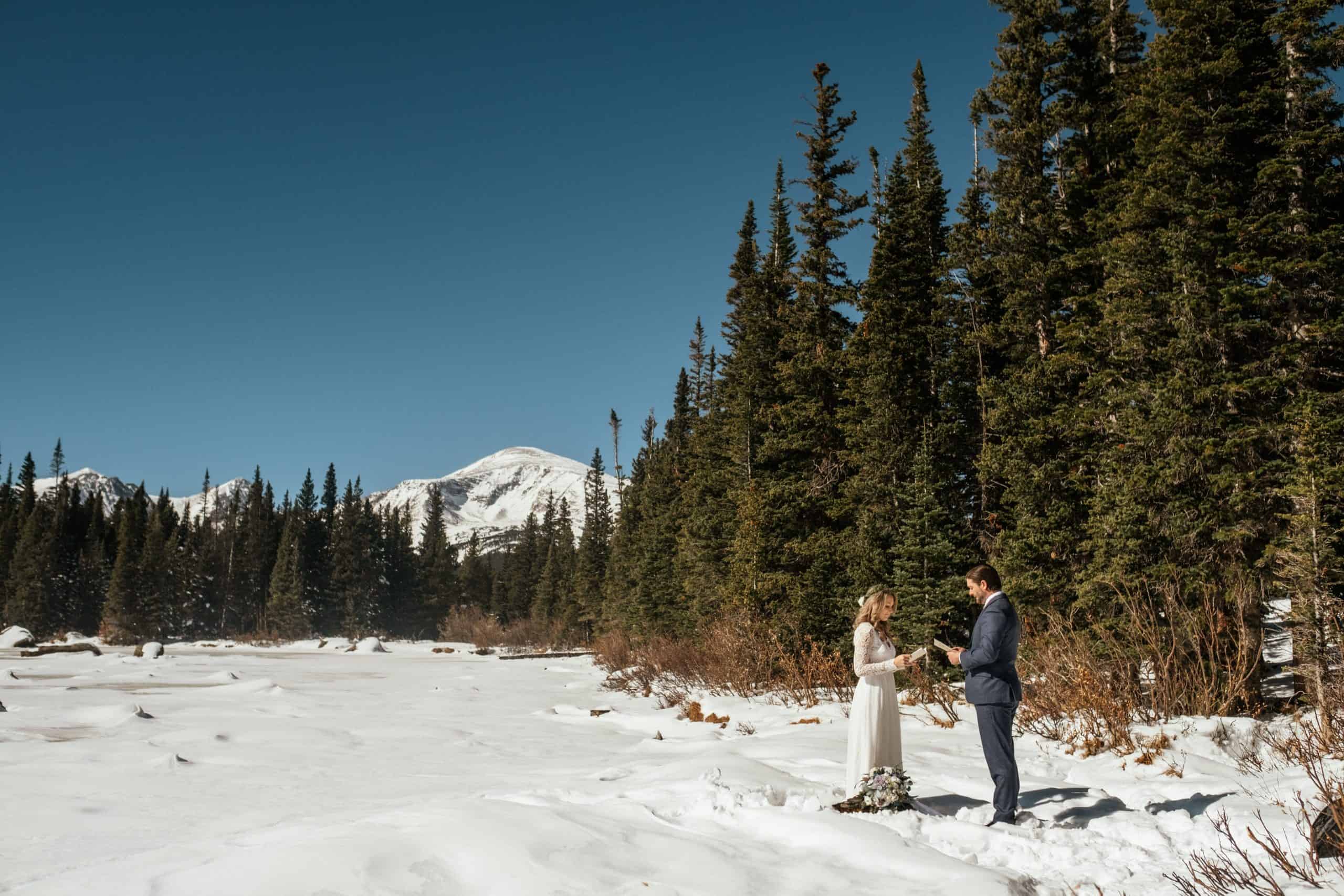 Couple saying vows in snow at Brainard Lake, Colorado elopement