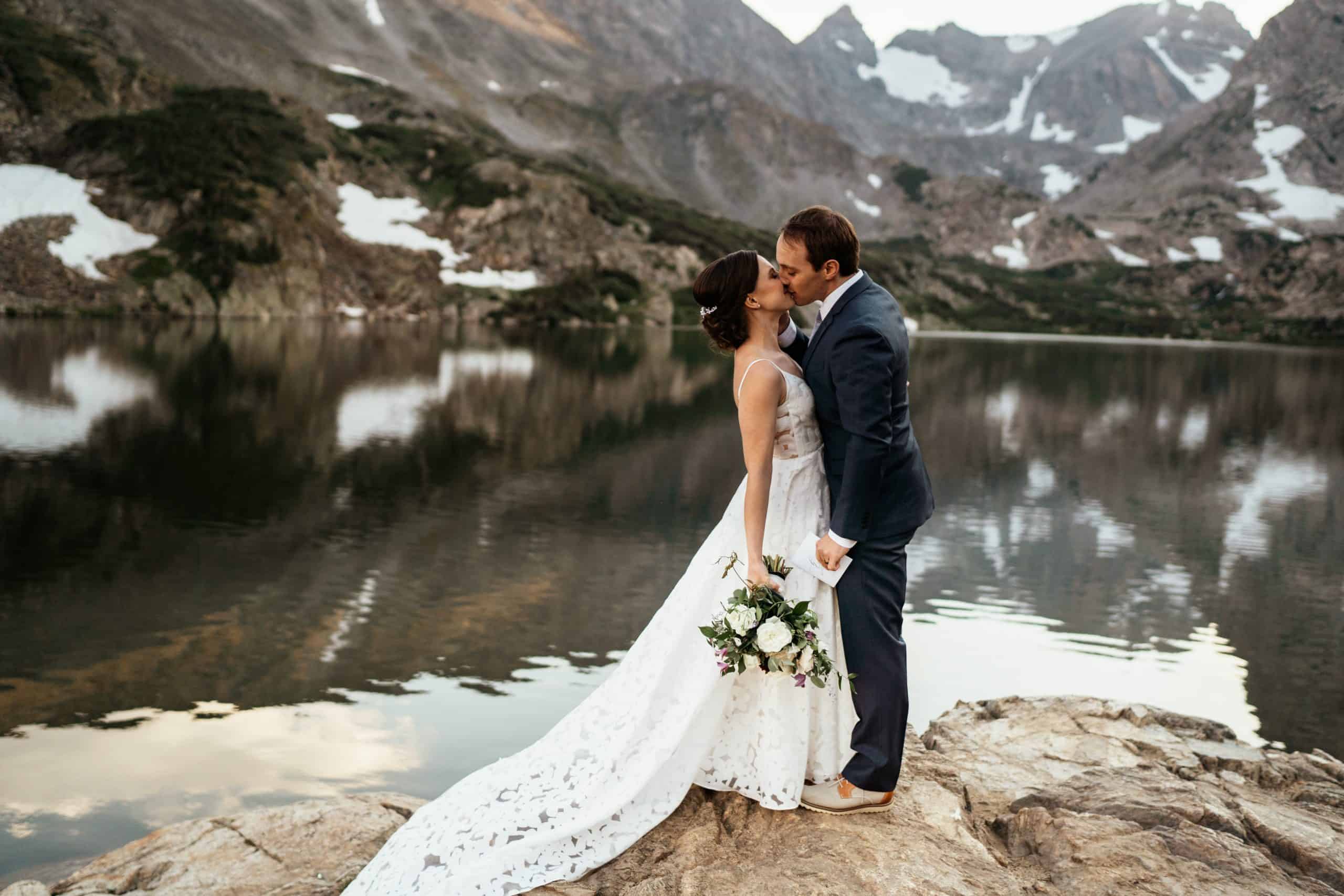 Couple kissing next to lake at colorado hiking elopement