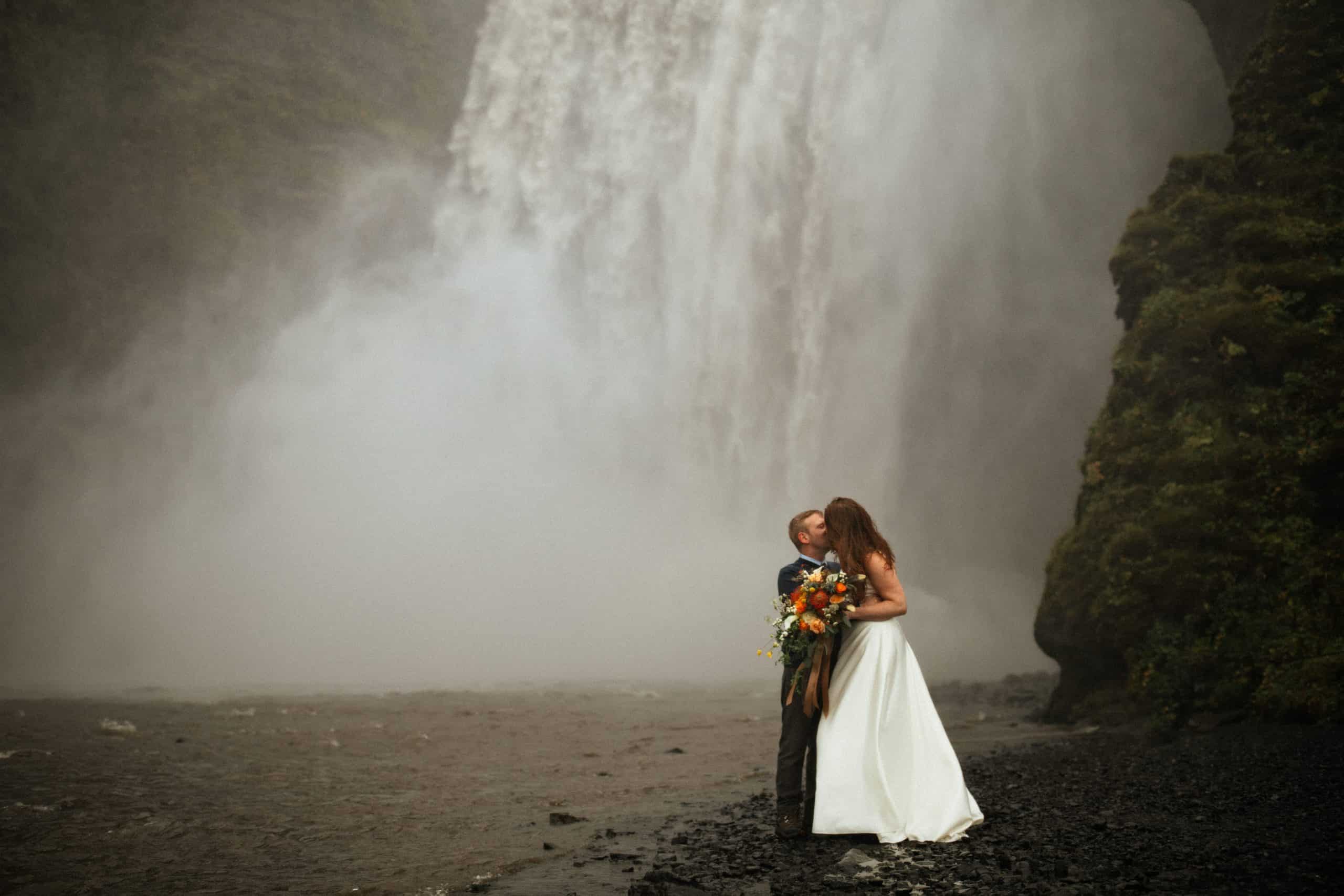 couple eloping in front of skogafoss waterfall in Iceland