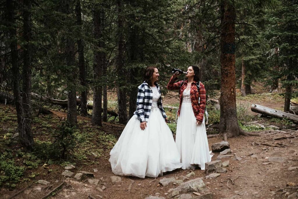 two brides drinking champagne at Colorado hiking elopement