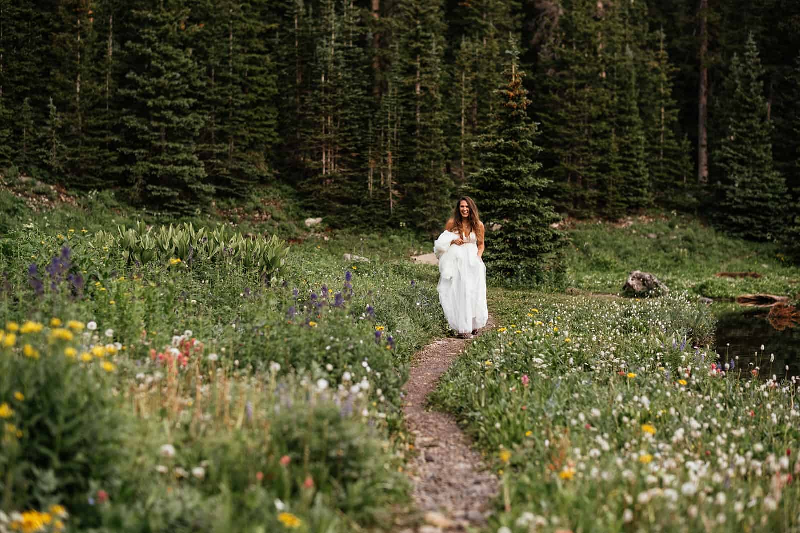 bride walking down aisle of wildflowers at Colorado elopement