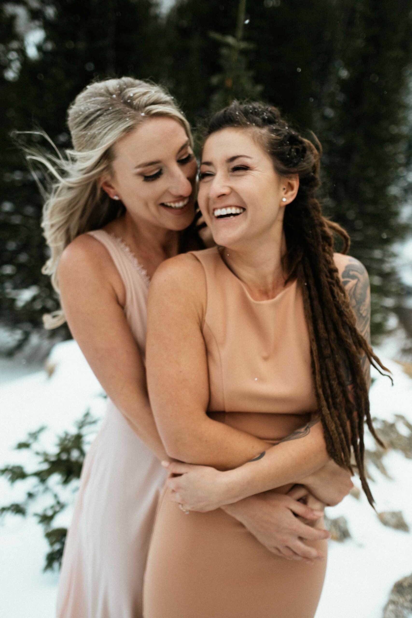 Two brides cuddle in the snow at Breckenridge, Colorado elopement