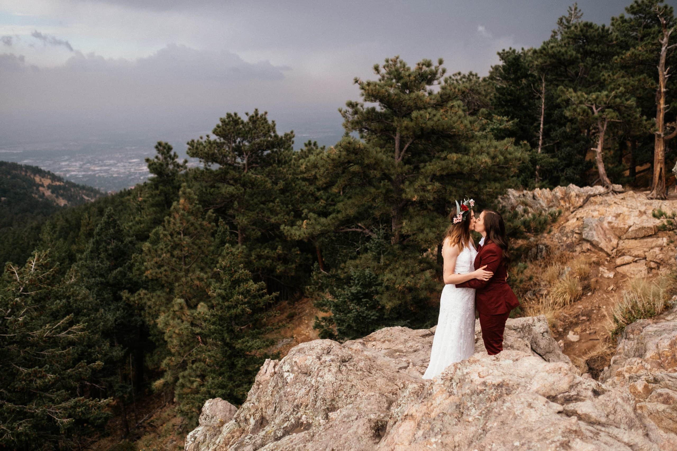 Two brides kissing on mountain at boulder colorado elopement