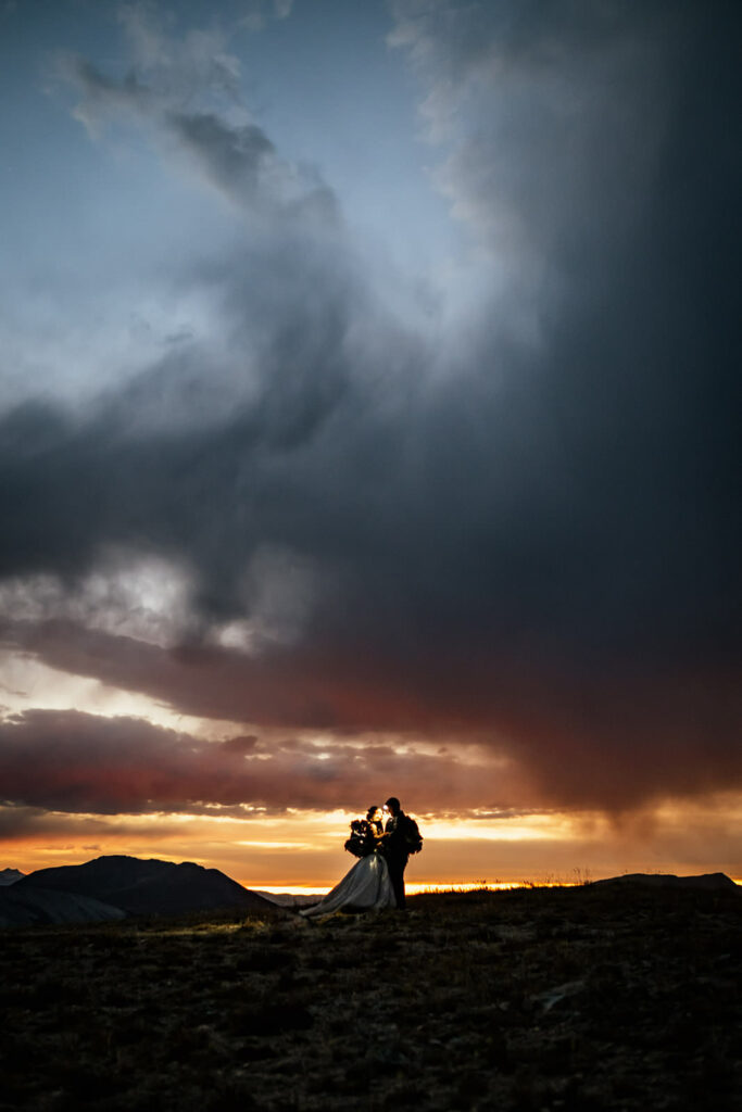 bride and groom on top mountain at sunset at Colorado hiking elopement