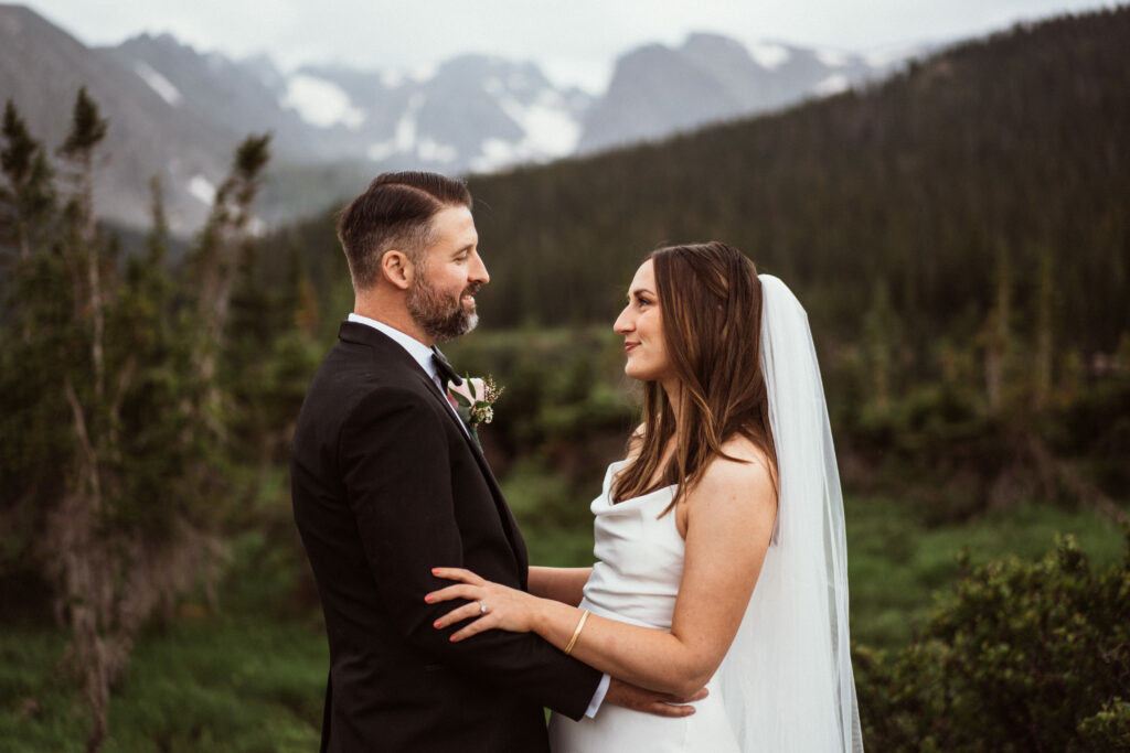 Bride and groom smiling at each other at Brainard Lake, Colorado wedding near Ward.