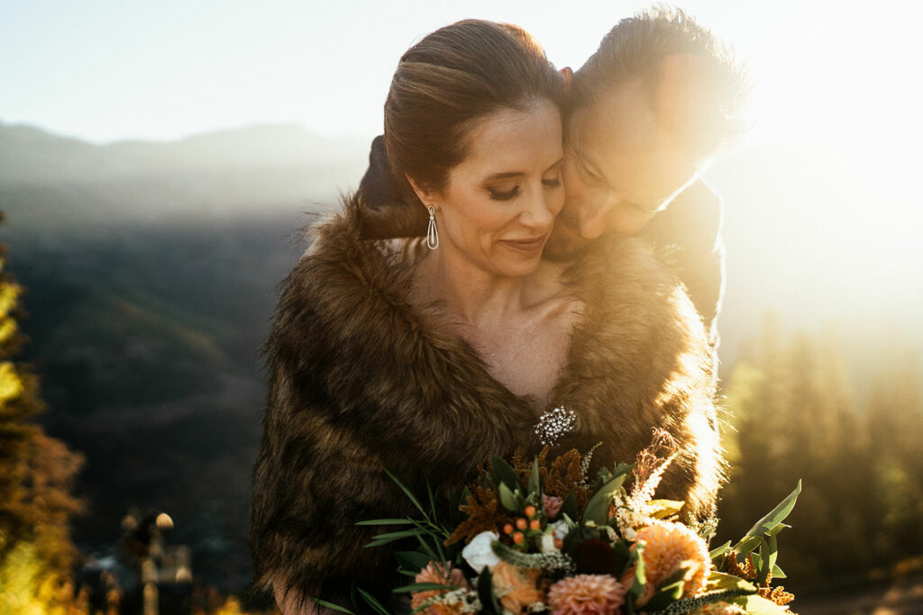 Bride and groom cuddle in golden light at Telluride, Colorado elopement.