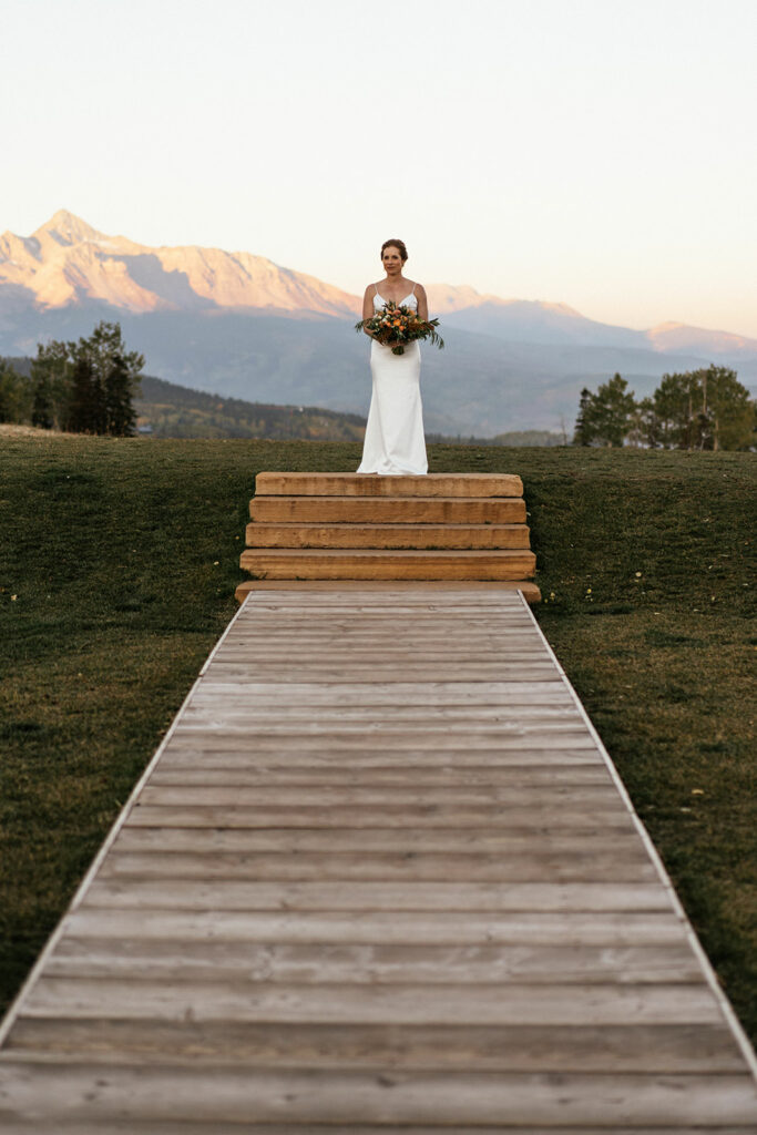 Bride preparing to walk down aisle with mountains in background at Telluride, Colorado elopement at San Sophia overlook.