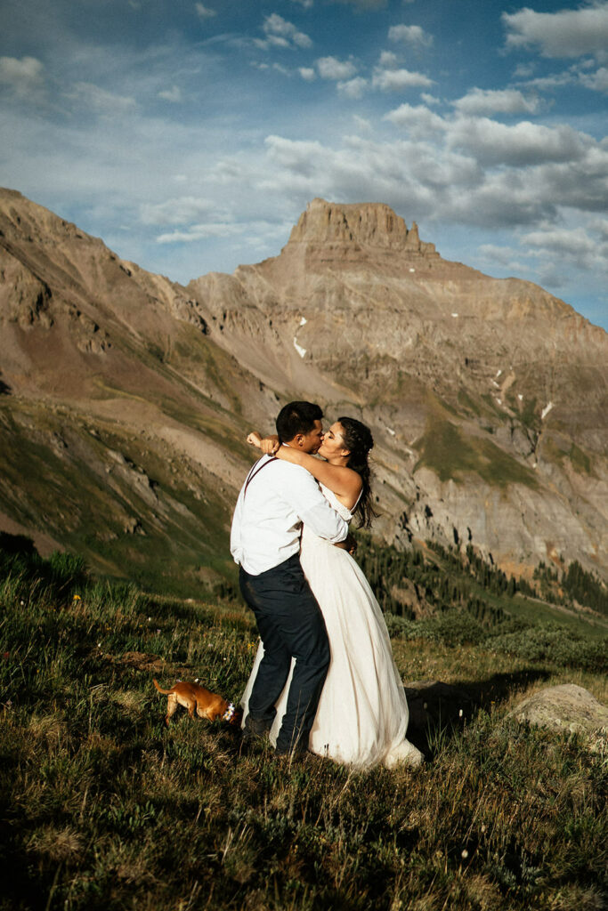 Bride and groom in wedding clothes doing first dance on top of a mountain at Colorado destination elopement wedding